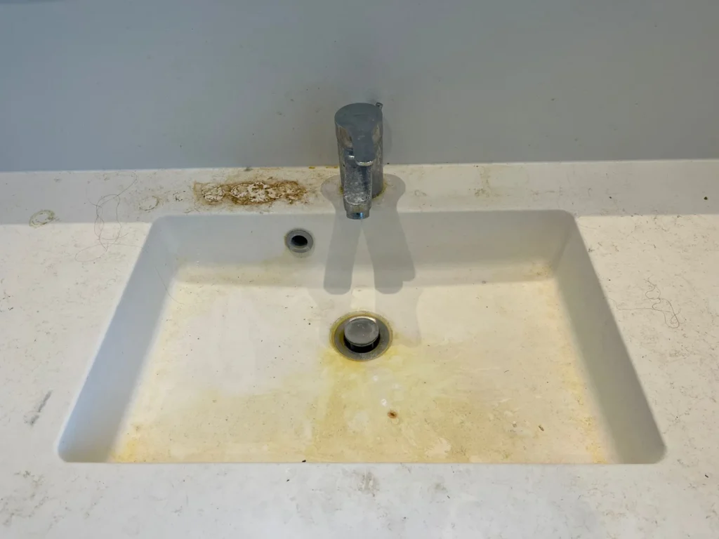 Håndvask på gæstetoilet med snavs og kalk før rengøring