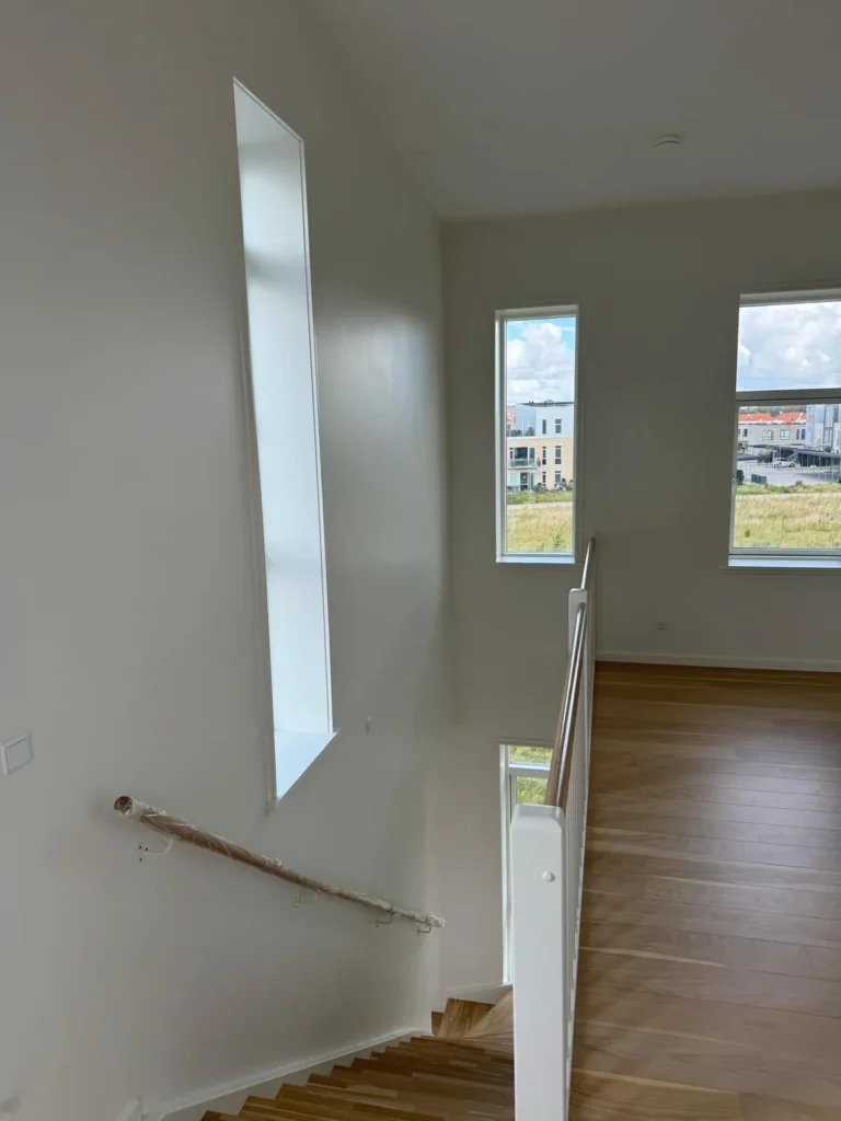 Lyse vægge og vinduesniche ved en indvendig trappe